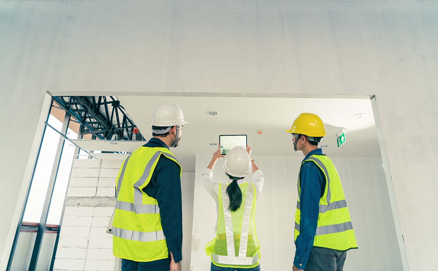 Behind Team Architect team building inspection with augmented reality application on digital tablet at construction site. Concept augmented reality technology in construction business.